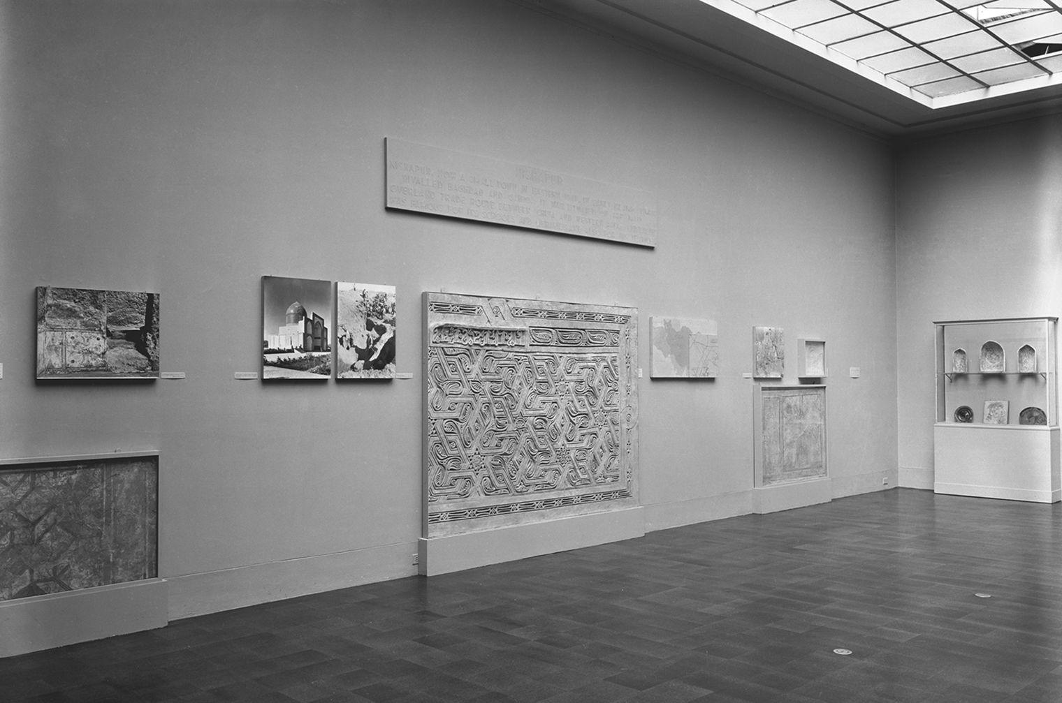 Black and white photo of gallery from 1949 with Nishapur stucco panels on the wall 