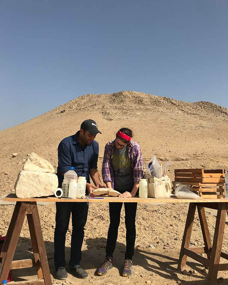 Two Met conservators on site in Dahshur looking down at a work table