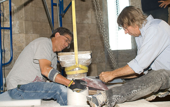 Rudy Colban and Fred Sager using thin saws to cut through the mortar joins. The original stone elements were covered with various types of protective wrappings.