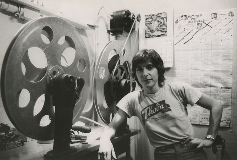 A black-and-white photograph of the author, Robin Schwalb, standing beside a rewinder at the Thalia Theater in New York City, circa 1978.