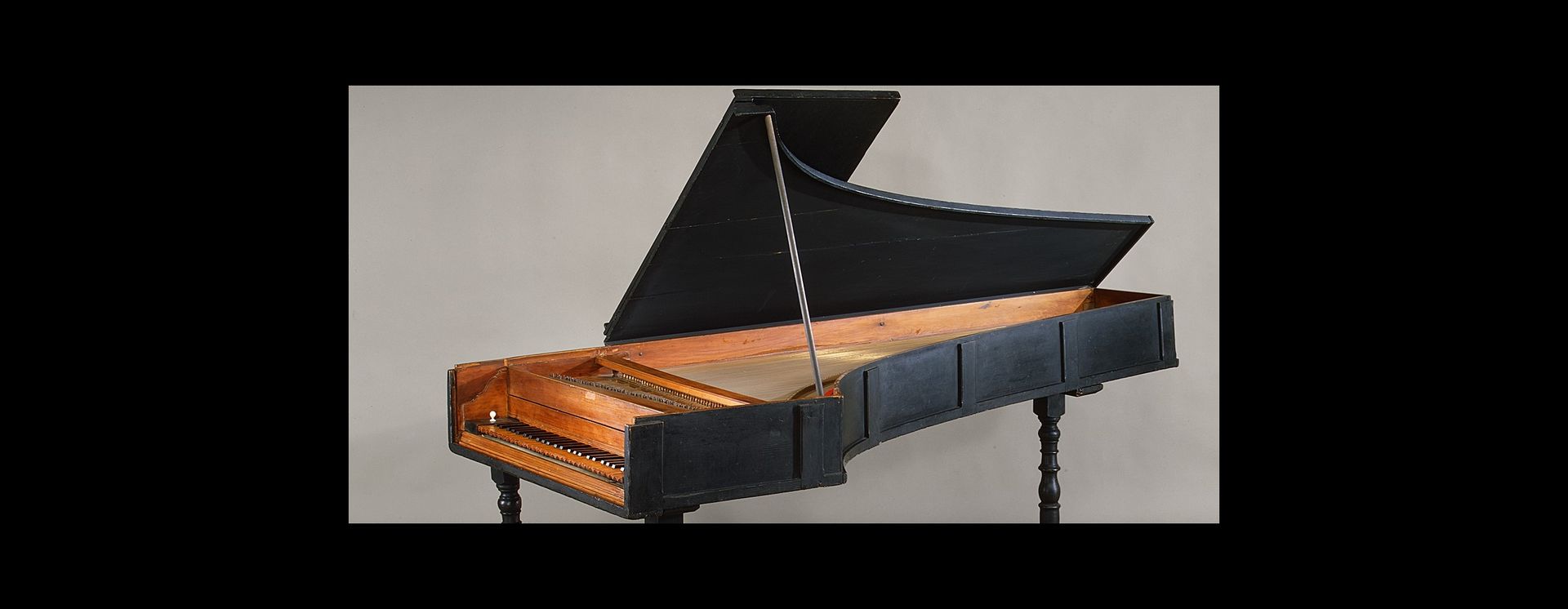 A seventeenth-century grand piano, made of cypress and boxwood, in front of a gray background