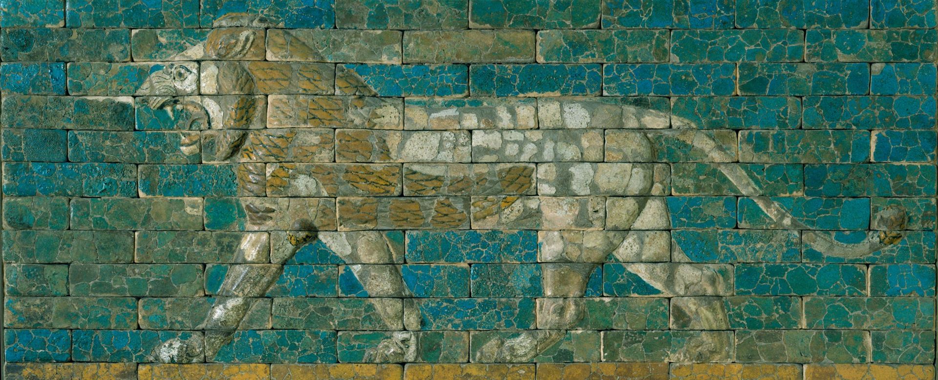 Panel with striding lion, facing left, made of blue, tan and ochre ceramic tiles