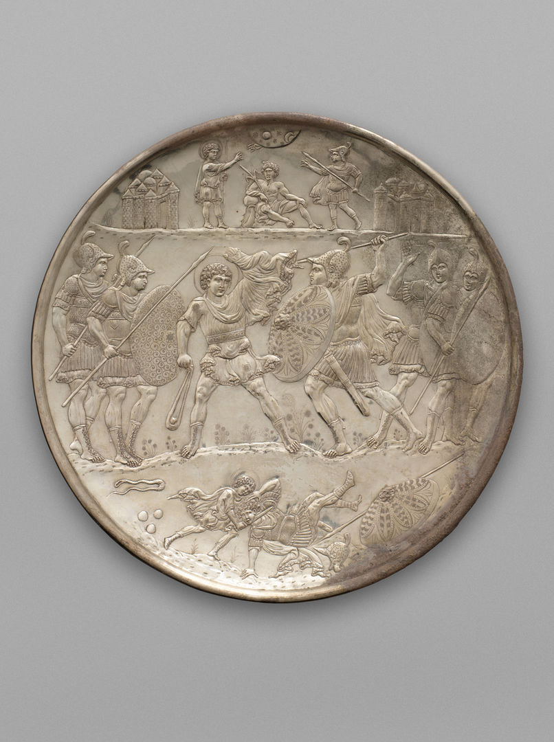 A large silver plate decorated in relief of two armies engaged in battle