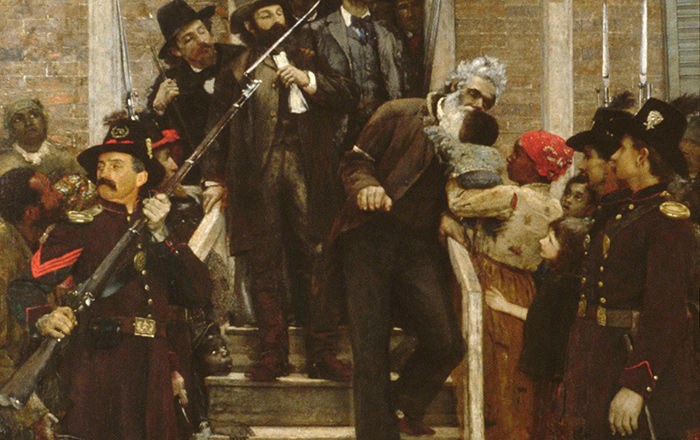 A prisoner in arm cuffs exiting the front door of a house, leaning down to kiss a baby in the arms of a woman; on the street, armed guards line the entrance to the stoop of the house 
