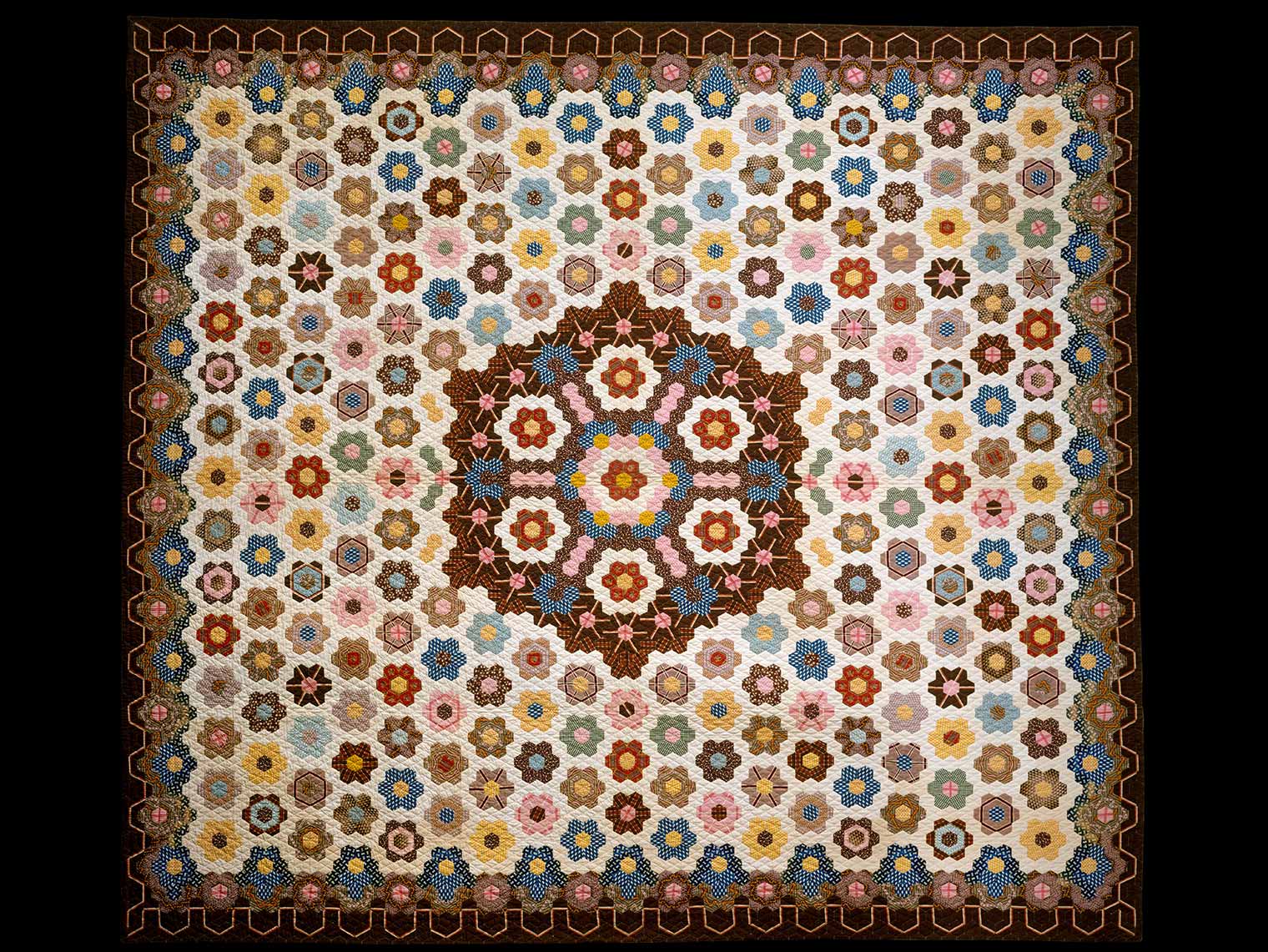 A rectangular quilt designed with colorful hexagonal shapes.