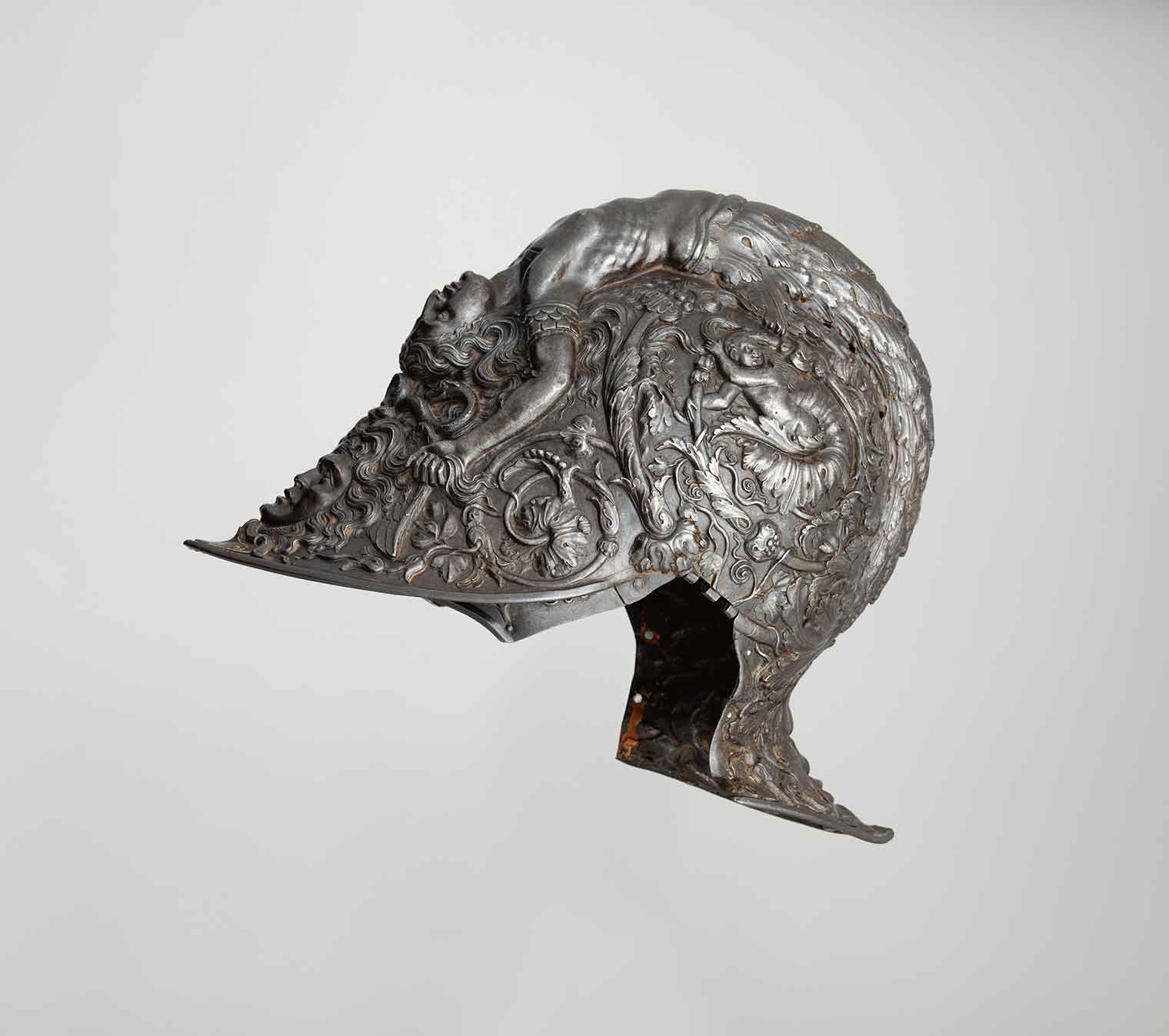 A silver helmet with a mermaid design and other ornate patterns.