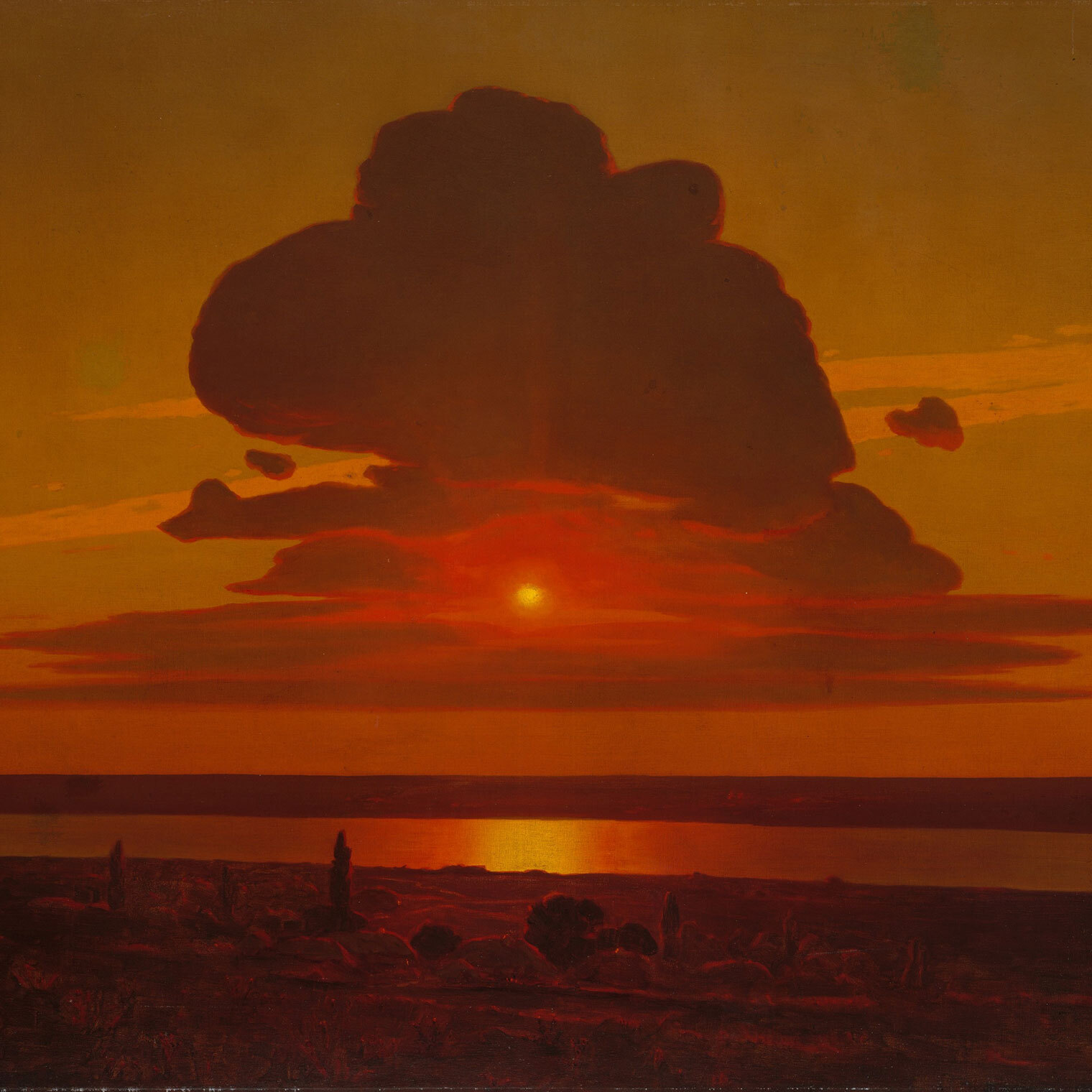 Red-hued photograph of a beach, and dark clouds over a blazing orange-hued sunset in the horizon.