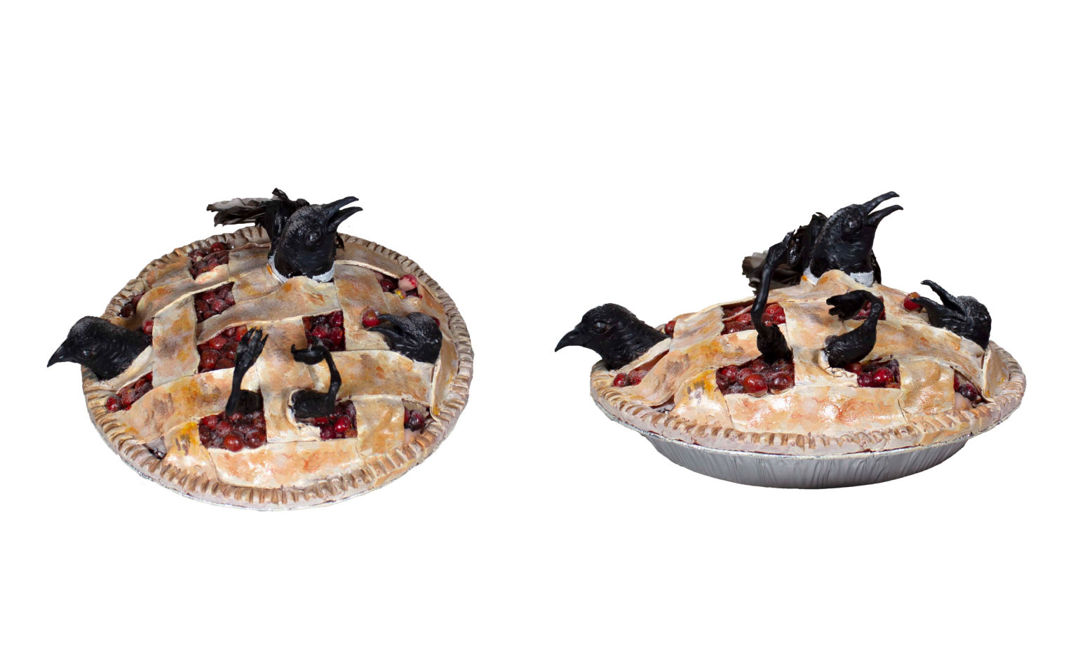 Sculpture of black birds bursting out of a pie with a lattice top.