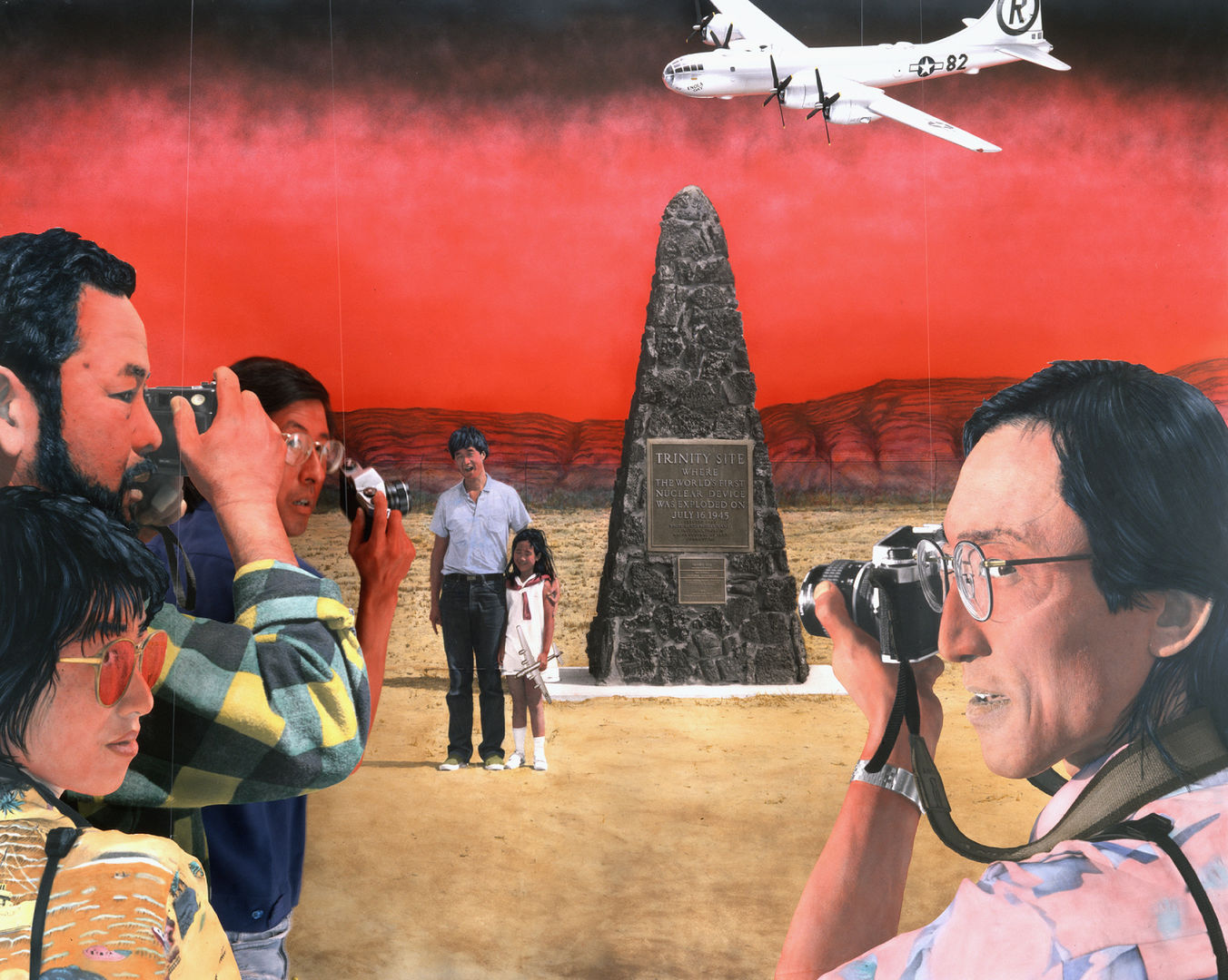 A man and young girl pose next to a nuclear memorial for a group of several photographers