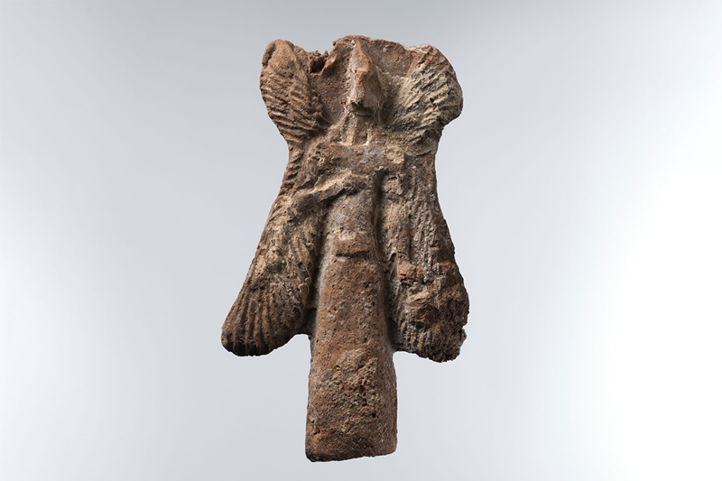 Assyrian ceramic Apkallu figure: bird-headed, winged figure carrying a bucket