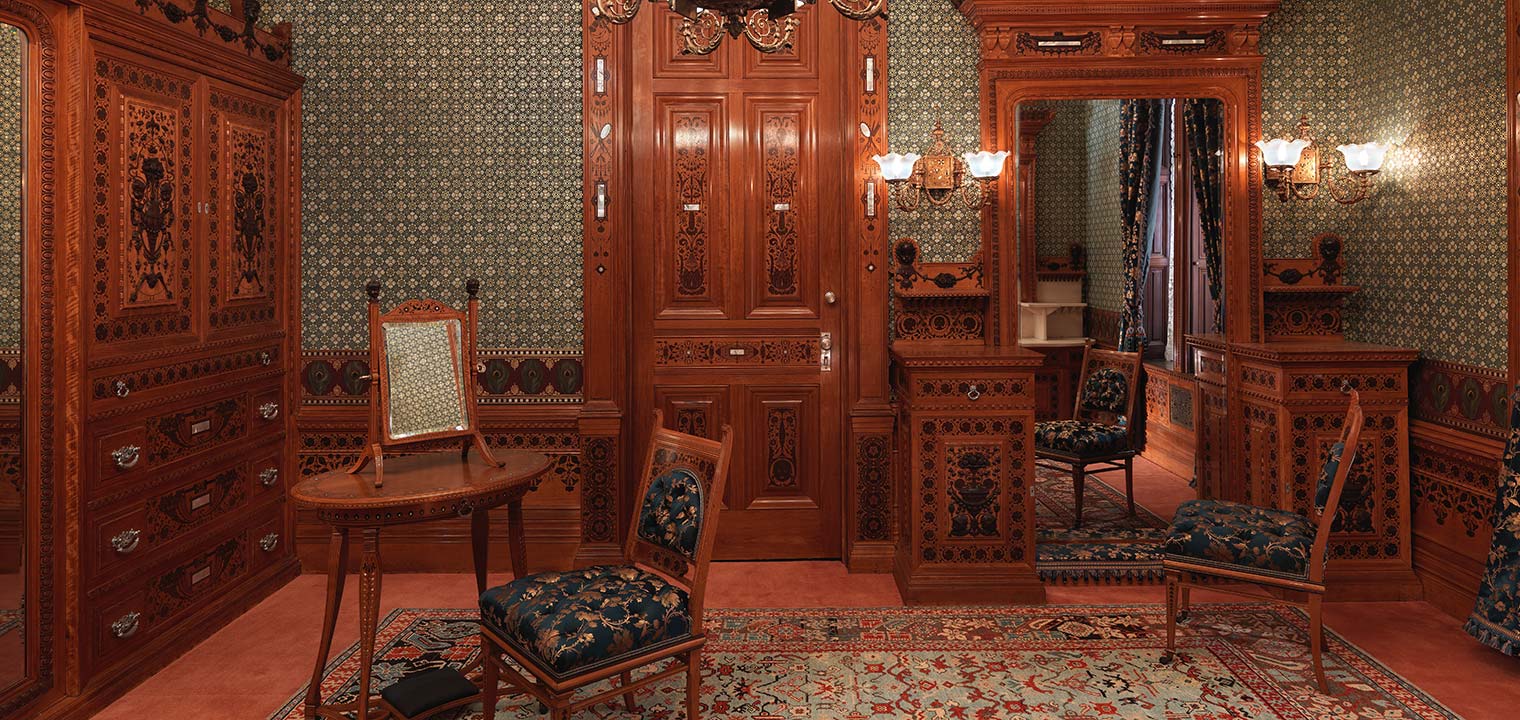 Interior of the Worsham-Rockefeller Dressing Room at The Met with late-19th-century chair, dressing table, mirror, wood paneling, and wall decor