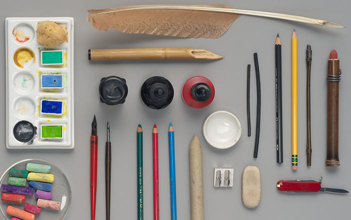 An assortment of drawing materials on a gray surface.