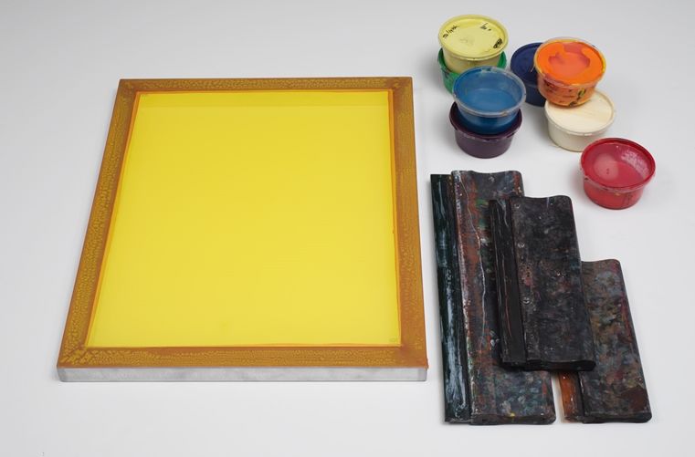 A selection of screenprinting tools: screen, screen frame, squeegee, and ink