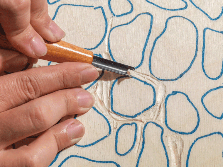 Animated image of a design being cut into a woodblock