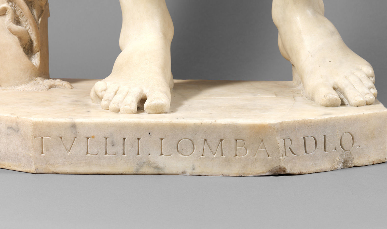 Detail image of Adam's base showing Tullio Lombardo's signature carved into the marble.