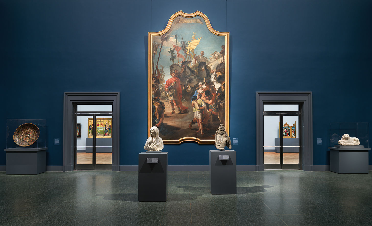 The dark blue walls of the European Paintings entry hall, along with Tiepolo's imposing painting, cast a dramatic tone. Four smaller objects and statues are displayed in this gallery.