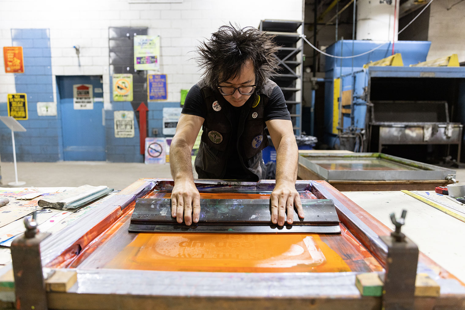 Photograph of the artist sTo Len at work screenprinting.