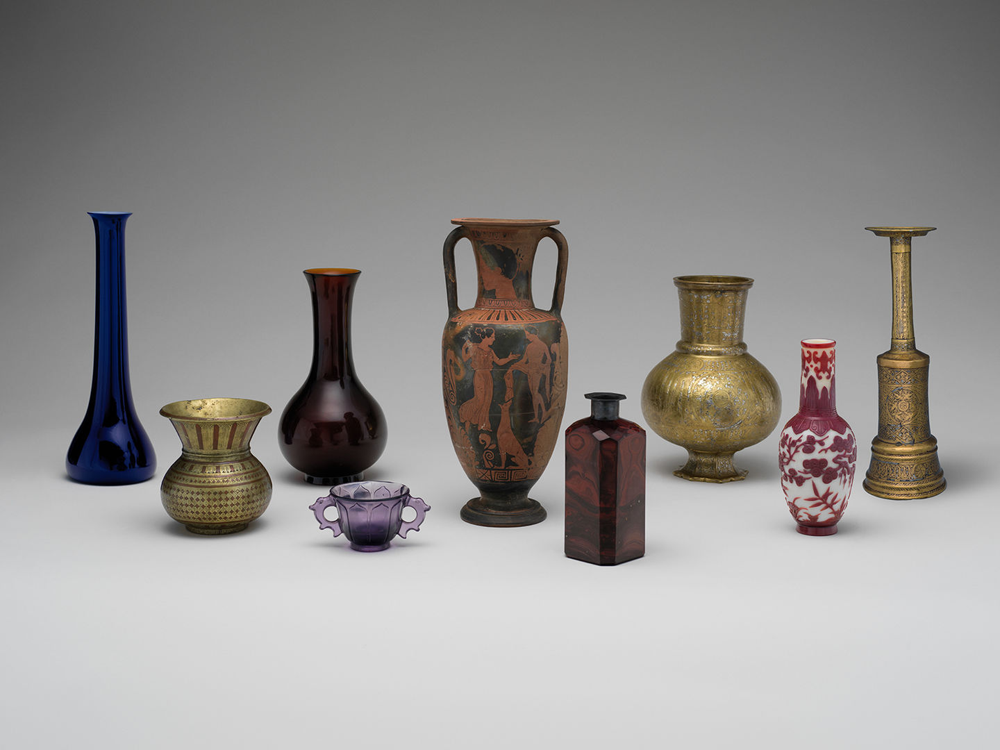 Photograph of nine objects in the Collecting Inspiration exhibition. All objects are vases or cups of various sizes, shapes, and colors.